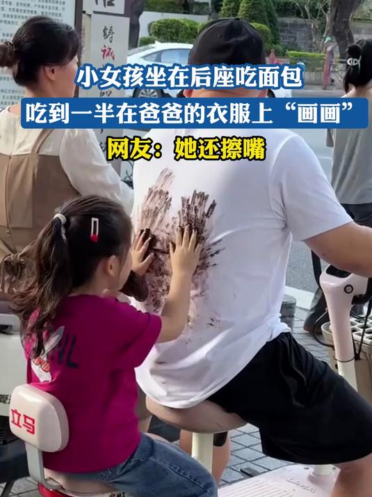 小女孩坐在后座吃面包,吃到一半在爸爸的衣服上“画画”