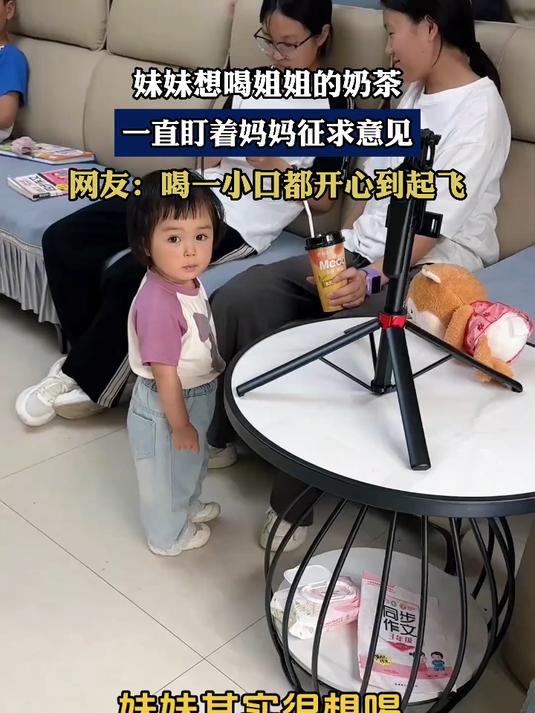 妹妹想喝姐姐的奶茶,一直盯着妈妈征求意见