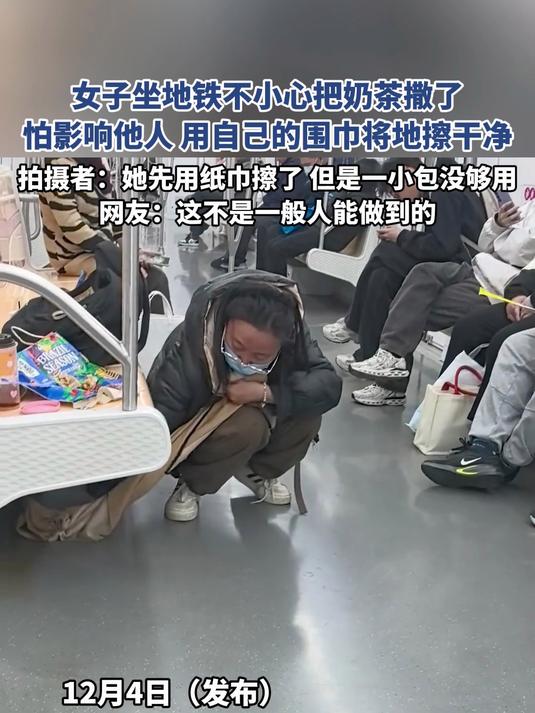 女子坐地铁不小心把奶茶撒了，怕影响他人用自己的围巾将地擦干净