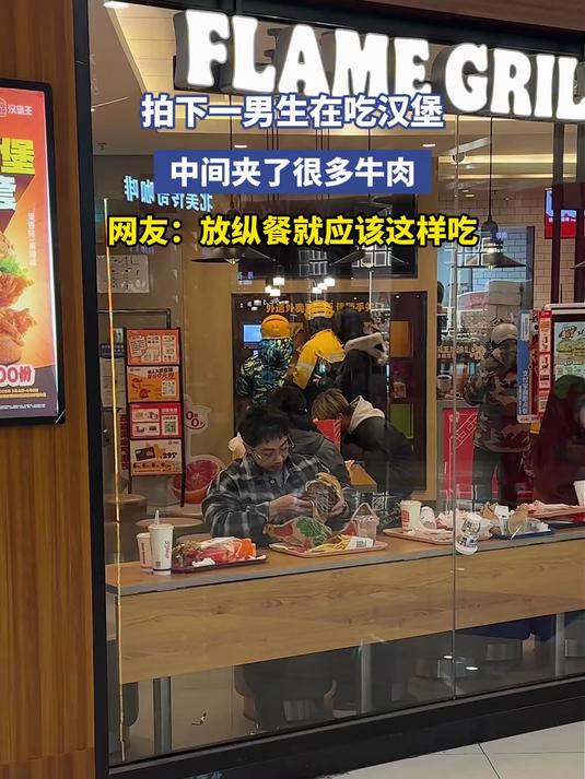 拍下一男生在吃汉堡,中间夹了很多牛肉,网友:放纵餐就应该这样吃