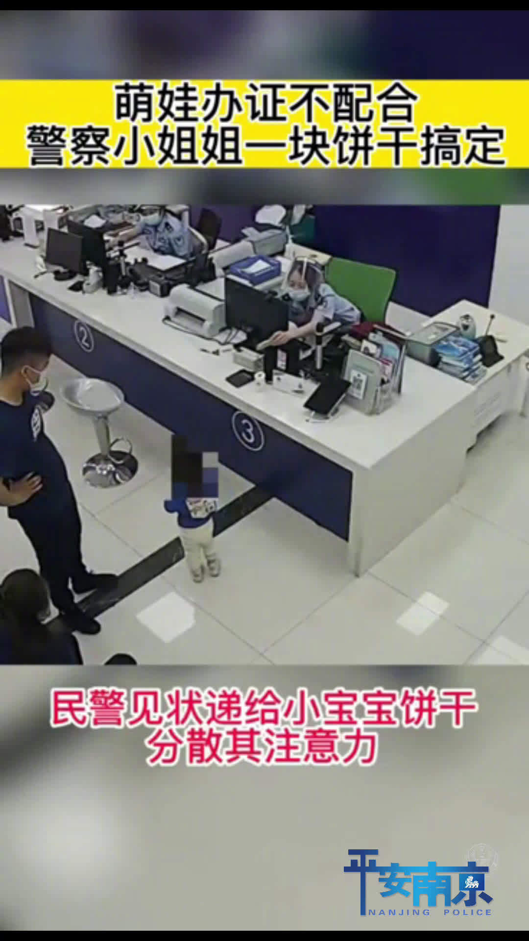 「可可爱爱!警花 一块饼干“搞定”萌娃拍照「大笑」」近日,江苏南京。一对年轻夫妻带着3岁萌