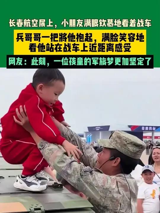 近日吉林长春 长春航空展上,小朋友满眼钦慕地看着战车,兵哥哥一把将他抱起,满脸笑容地看他站