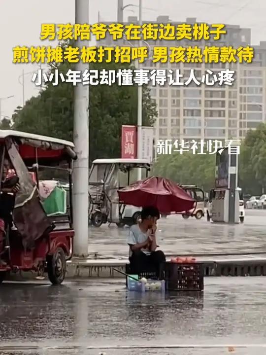 “小孩哪有不贪玩的时候啊”,男孩陪爷爷在街边卖桃子,当附近煎饼摊老板来打招呼时,男孩热情款
