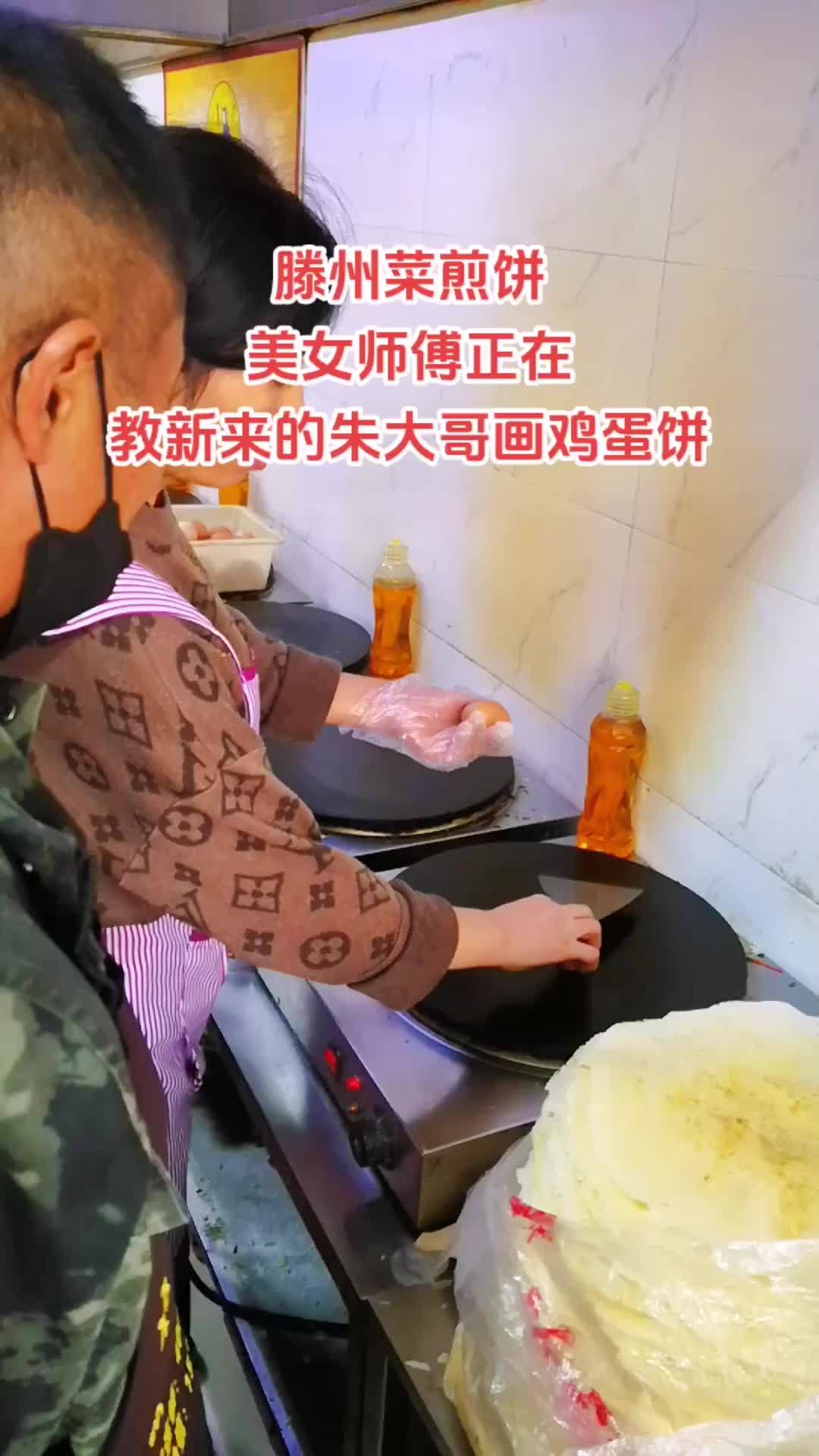 五十多的朱大哥之前做木工雕刻 今天来学习滕州菜煎饼 美女师傅正在教新来的朱大哥画鸡蛋饼 菜