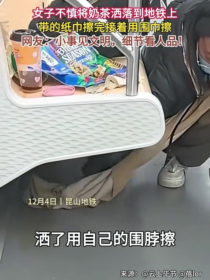 女子坐地铁不慎将奶茶洒在地上，身上纸用完了就用围脖擦拭！拍摄者：保持公共场所卫生，值得赞扬