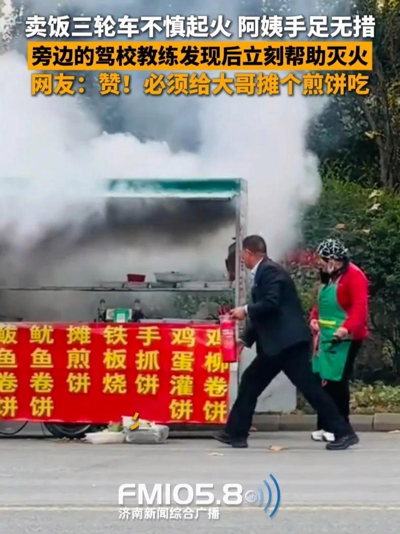 11月17日,山东临沂,街边卖卷饼的三轮车不慎起火,卖饭阿姨手足无措,旁边的驾校教练发现后