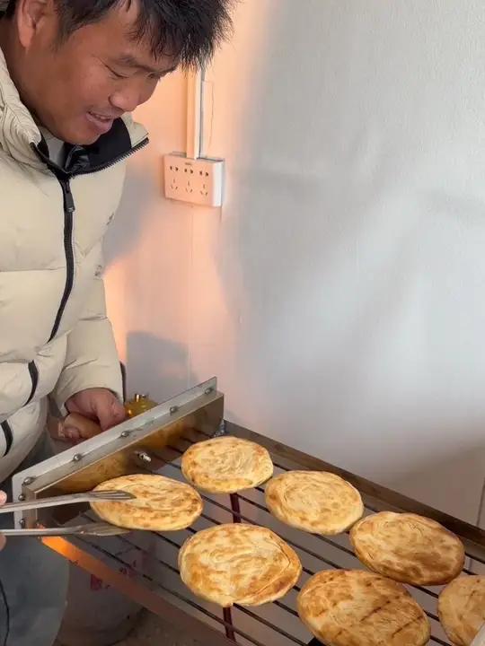 小斌亲手看管炉子炕出来的油酥烧饼焦香酥脆，开业后分工明确媳妇负责揉面做烧饼我负责管炉子，夫