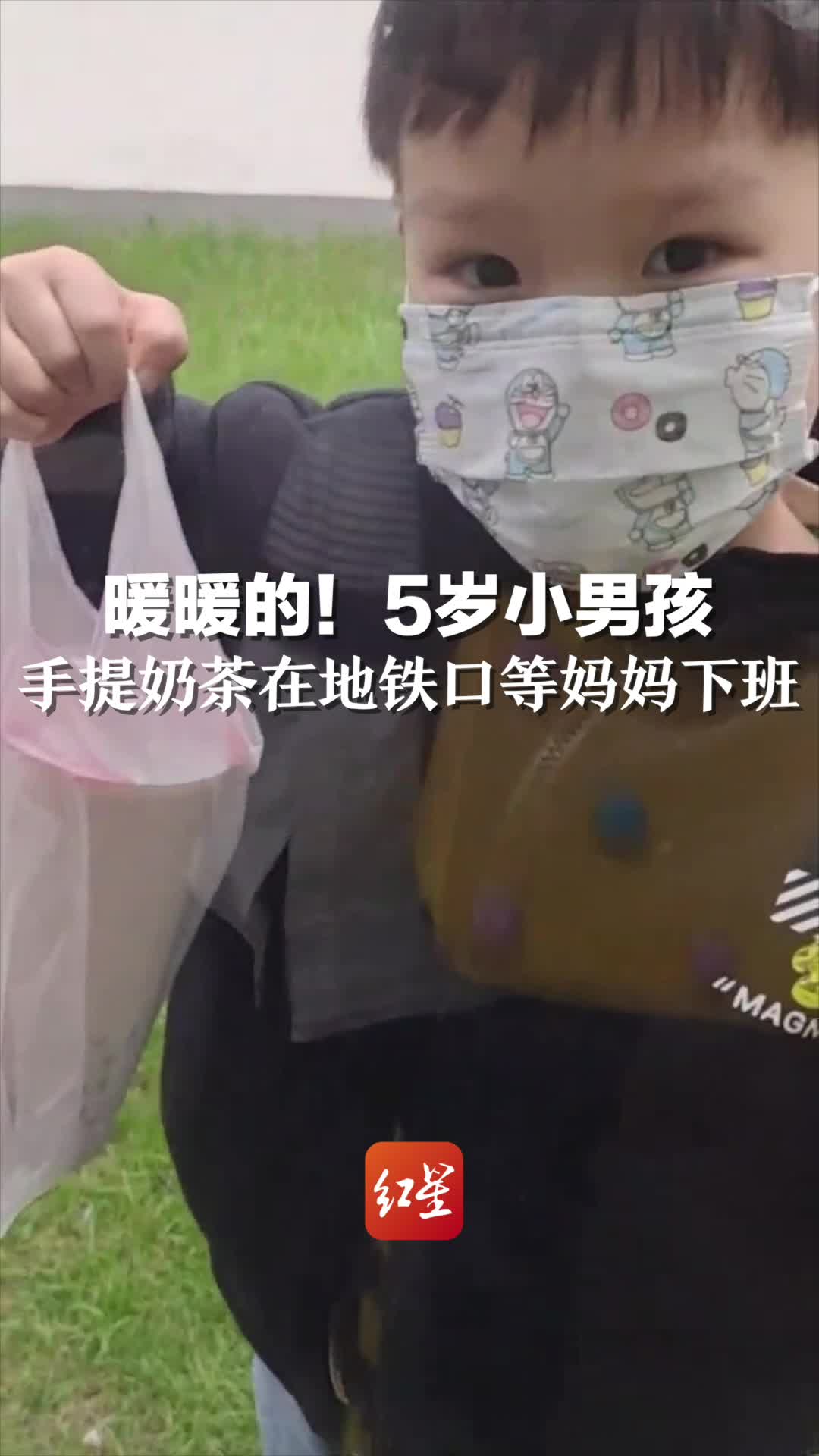 5岁小男孩手提奶茶在地铁口等妈妈下班。这一幕暖暖的!