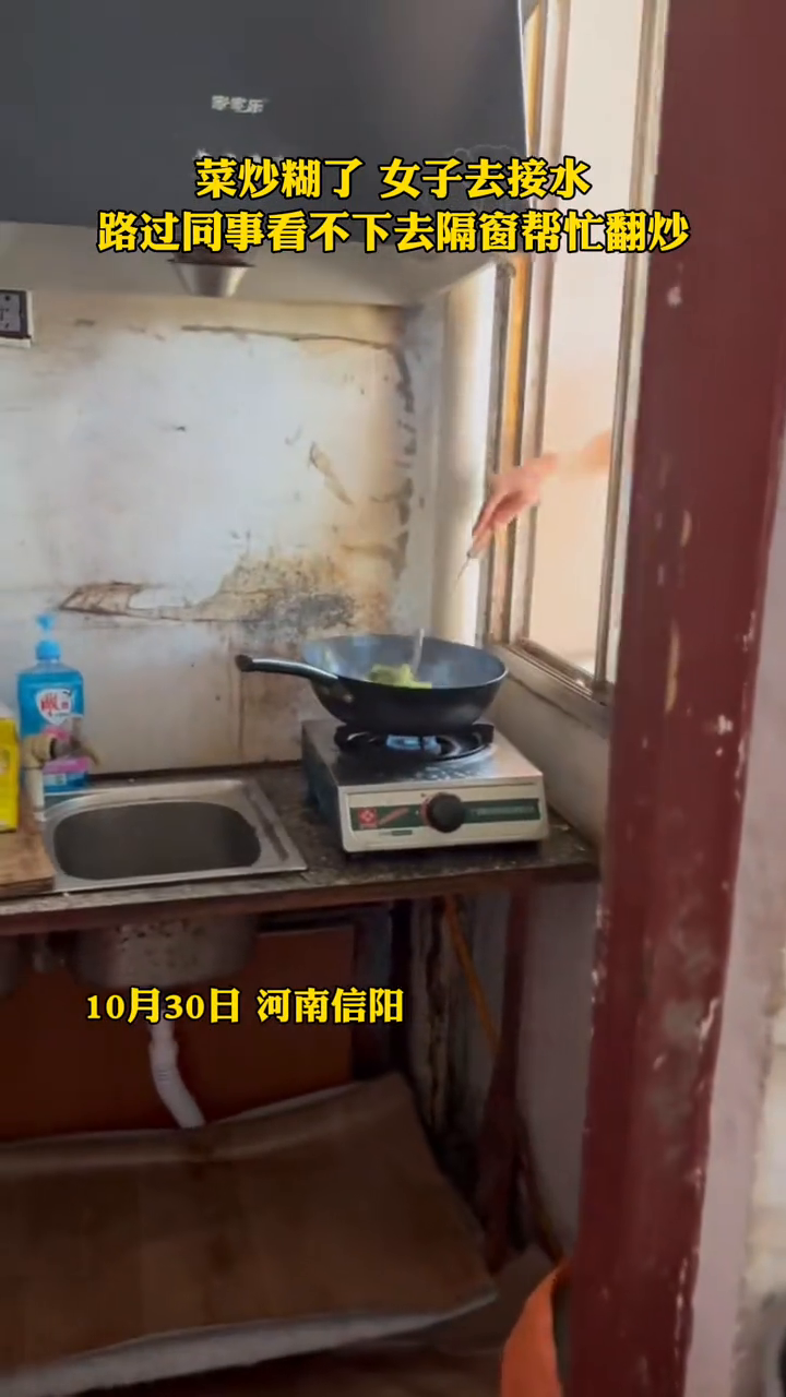 菜炒糊了,女子去接水,路过同事看不下去隔窗帮忙翻炒