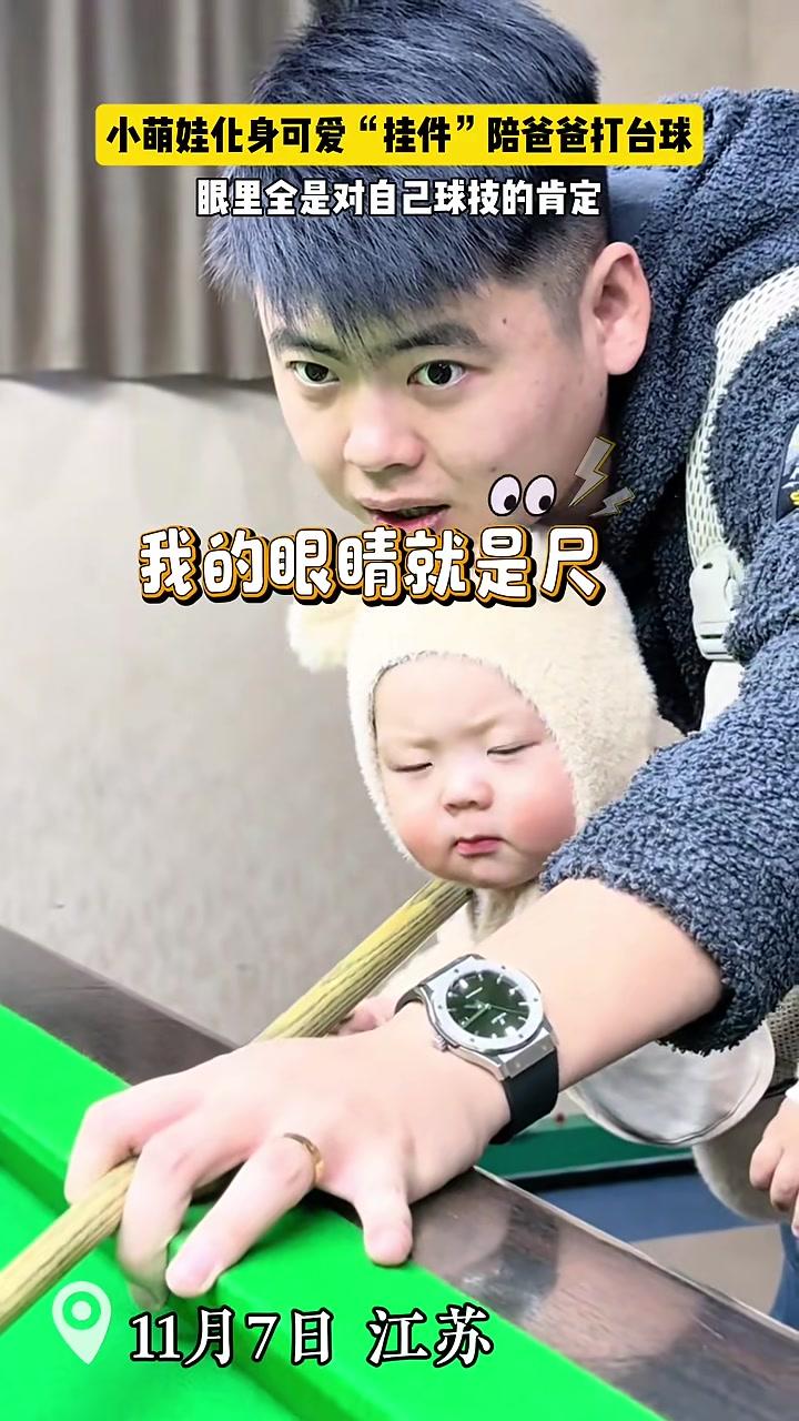 小萌娃化身可爱“挂件”陪爸爸打台球。眼里全是对自己球技的肯定……（来源：奶茶弟）