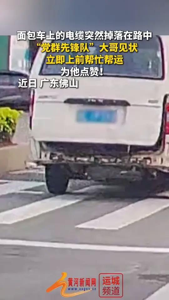面包车上的电缆突然掉落在路中，“党群先锋队”大哥见状立即上前帮忙帮运。为他点赞！（来源：中