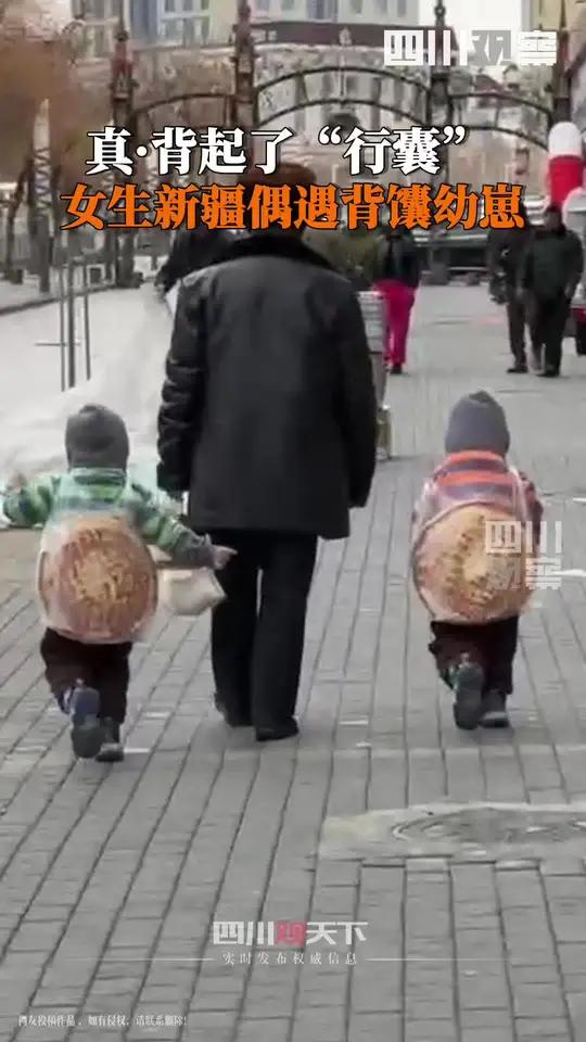 3月9日,新疆霍尔果斯。女生下楼买菜偶遇人类幼崽背馕:馕对于新疆人来说必不可少,这么大的馕