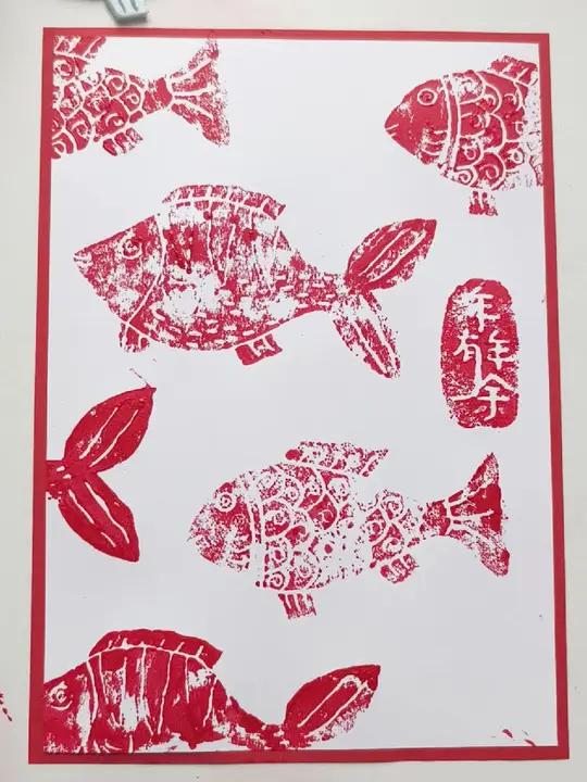 在吹塑板上雕琢鱼儿的轮廓,用颜料涂抹色彩,再拓印到纸上,“年年有鱼”跃然纸上,不仅是艺术的