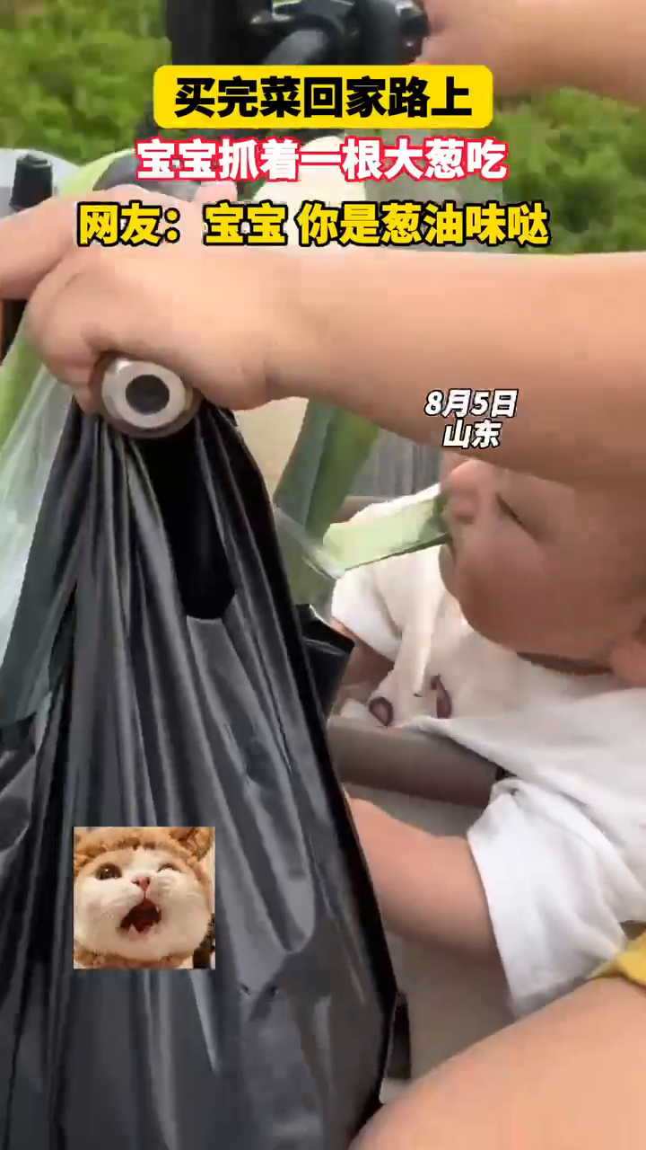 买完菜回家路上,宝宝抓着一根大葱吃