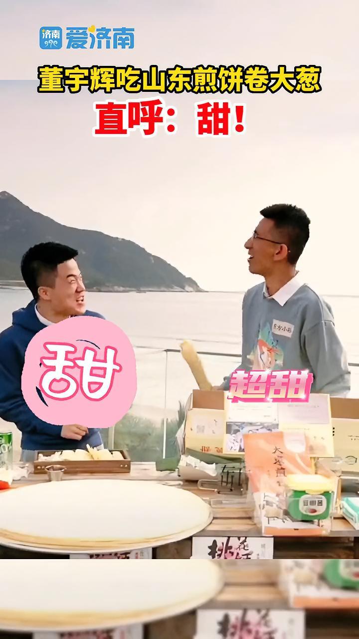 10月29日,山东青岛,董宇辉和东方小孙在直播过程中,拿出煎饼卷了一根大葱,开心试吃,咬完