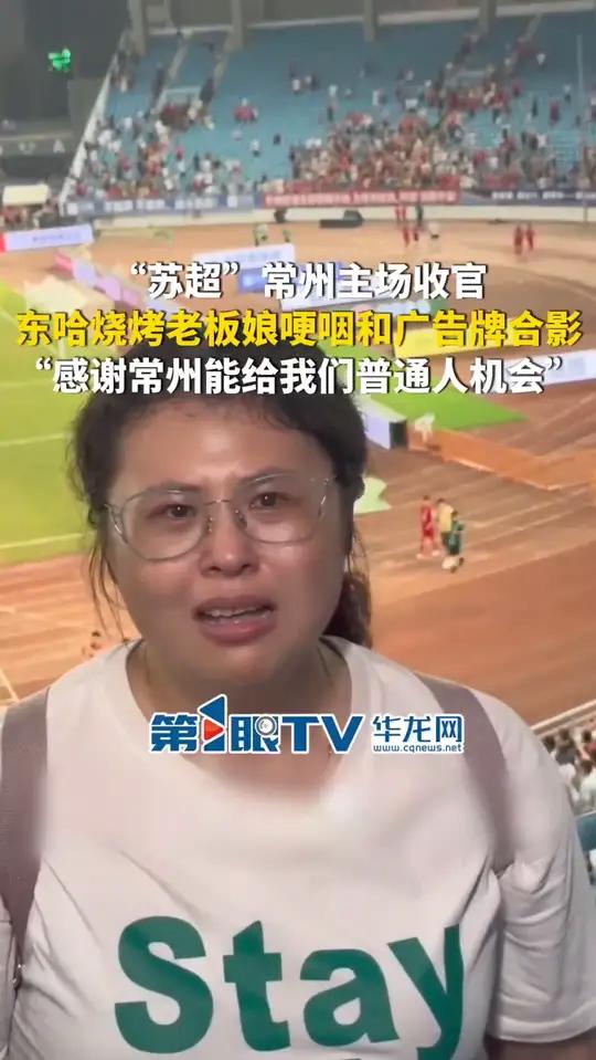 9月14日,江苏。“苏超”常州主场收官,东哈烧烤老板娘哽咽和广告牌合影:感谢常州能给我们普