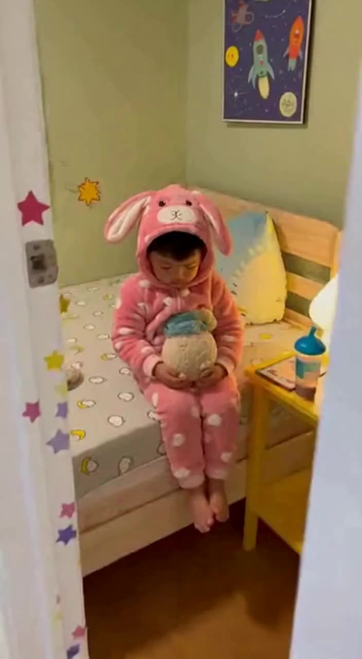 哇 穿兔子装的小家伙抱着玩偶呢