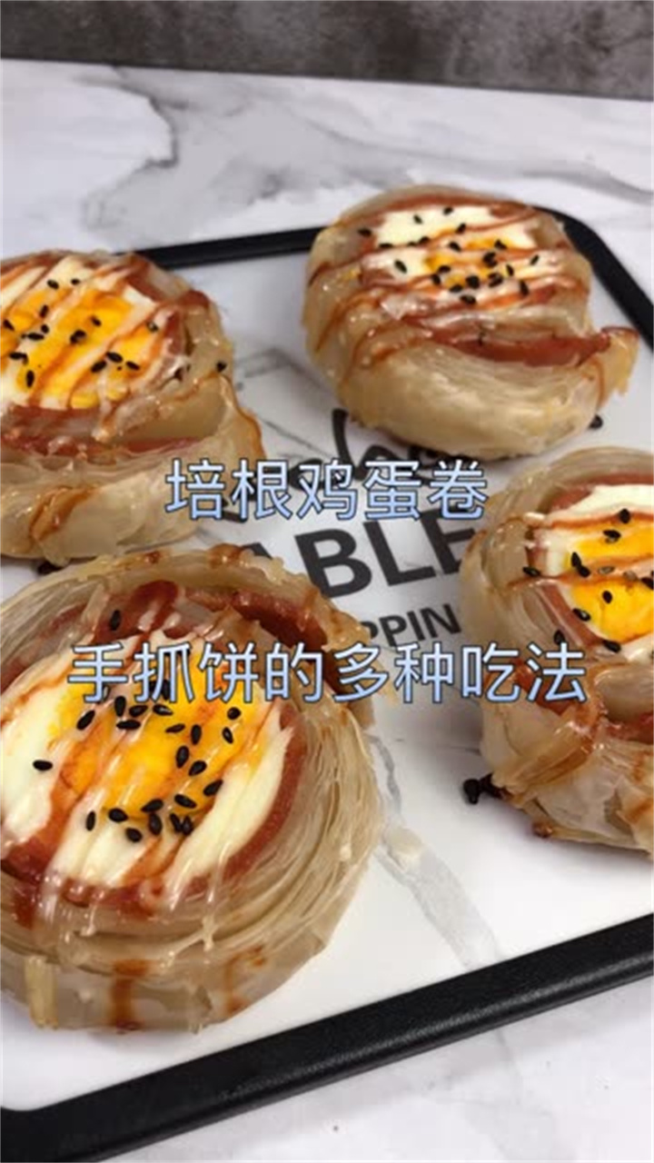 培根鸡蛋卷原料:手抓饼皮2张,培根2片,水煮蛋2个沙拉酱、蕃茄酱、黑芝麻适量烘烤