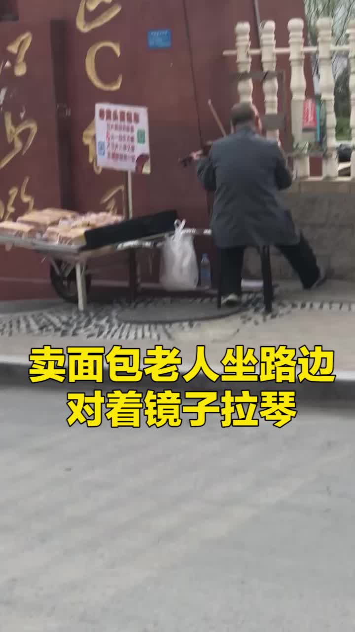 山东青岛 卖面包的老人坐路边对镜子拉琴 &nbsp;网友:左手生活,右手理想