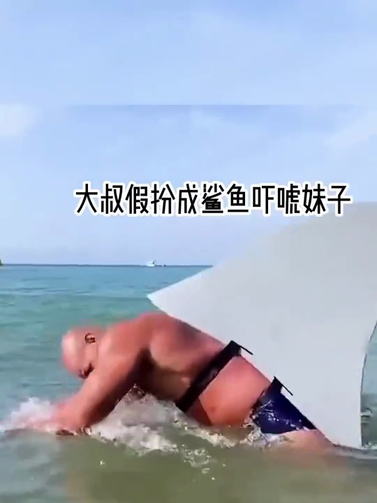 大叔假扮成鲨鱼,被妹子发现后,撒丫子往岸上跑