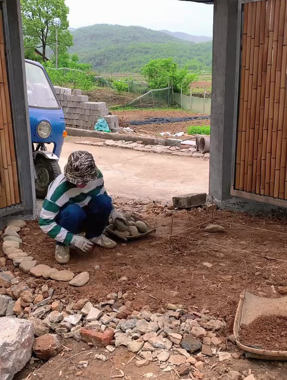 和老爸把没用完的鹅卵石,在侧门门口做一个鹅卵石花坛和花朵台阶