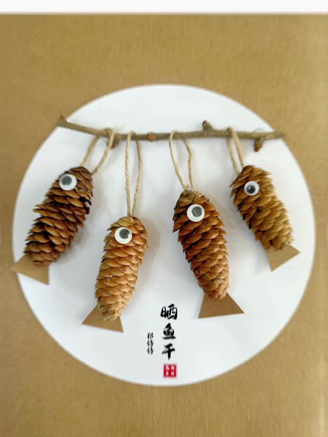 用秋天的松果来做幅晒鱼干创意手工画吧