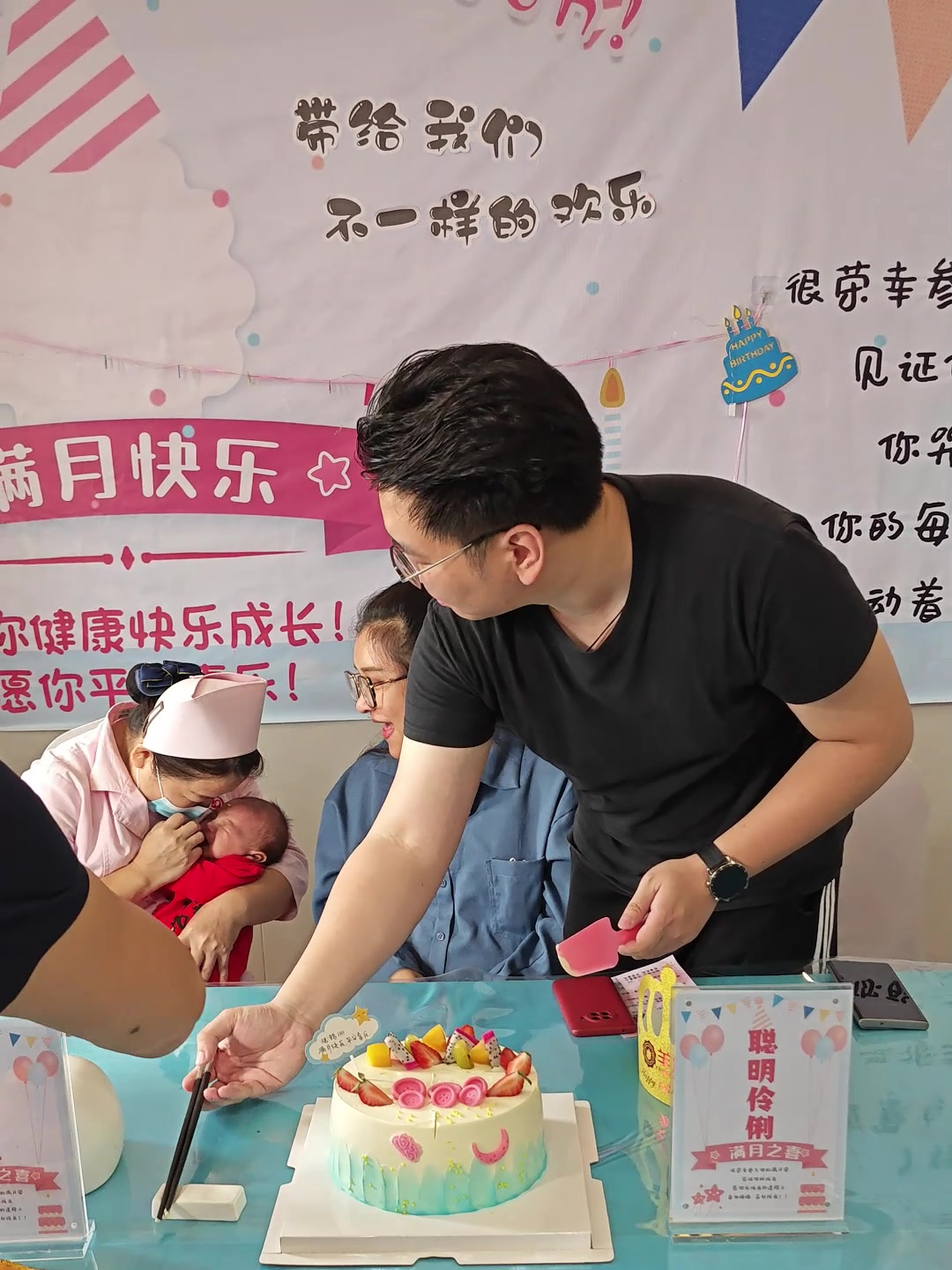 宝宝的满月仪式上,爸爸轻轻放了一小块蛋糕在宝宝的额头上