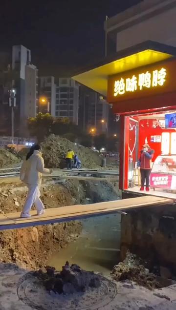 四川成都一街道 顾客踩木板跨沟买鸭脖 网友:不如改名绝命鸭脖