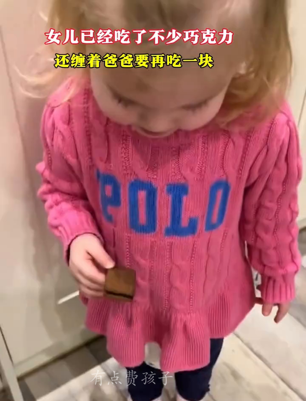 闺女已经吃了一堆巧克力,还撒娇让爸爸再给一块