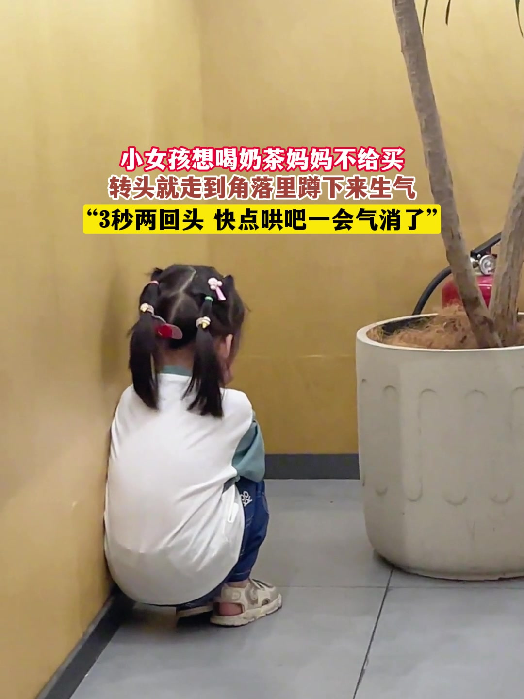 小女孩想喝奶茶妈妈不给买,转头就走到角落里蹲下来生气