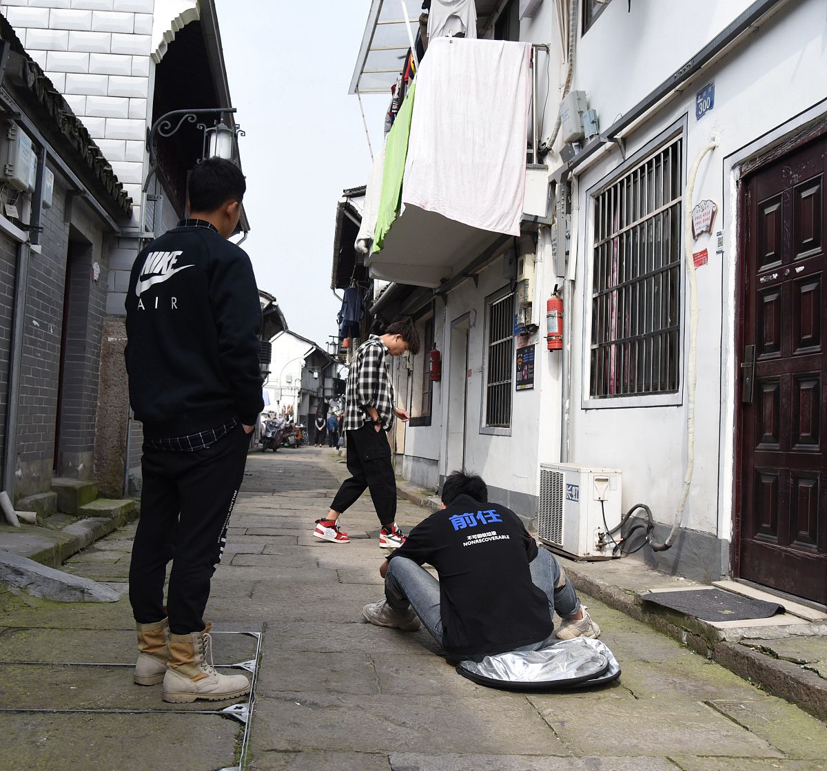 2019年3月16日,三个小伙子在西兴街上,为淘宝拍鞋子照片.
