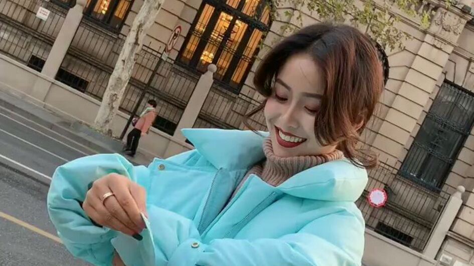 美女穿着蓝色羽绒服搭配高腰牛仔裤,时尚靓丽!