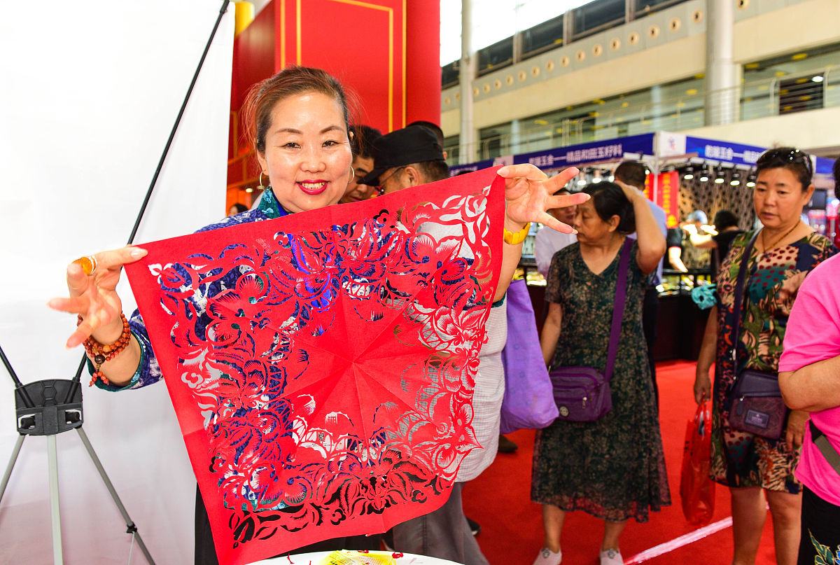 2018年6月15日,江苏扬州,展会上市民观看展览,玉器,漆器,瓷器等展品吸