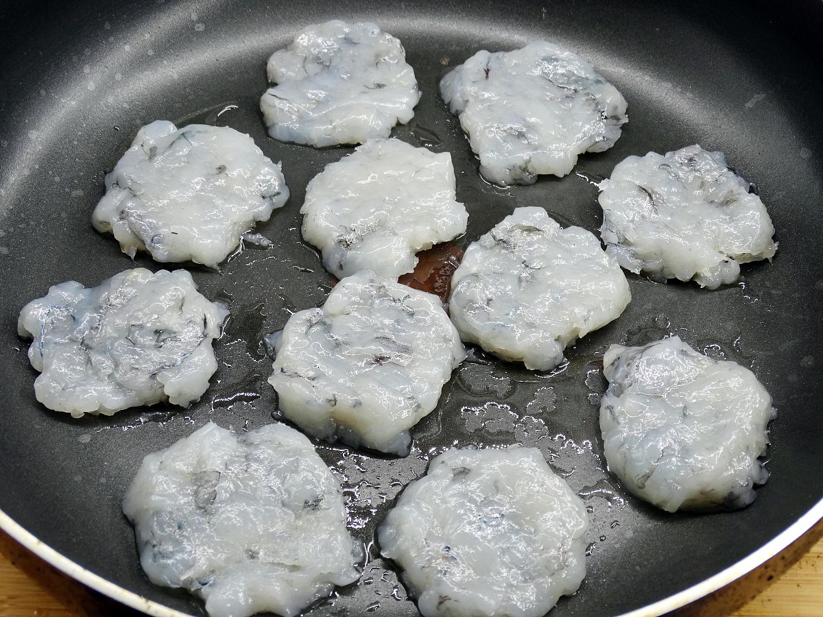 图为虾饼的制作过程 锅刷一层油,小火放入虾饼煎制,反复翻面.