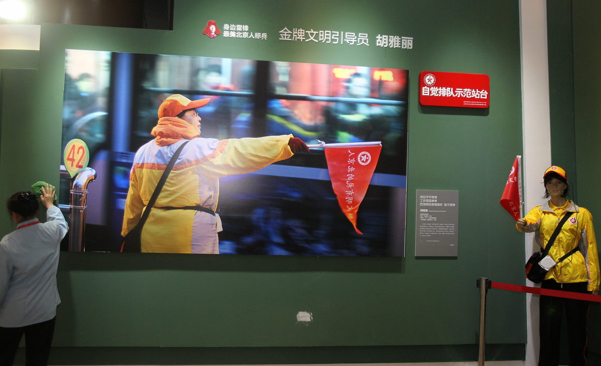 ***_***2013年3月3日,北京,工作人员在"永远的雷锋"大型主题展览"身边