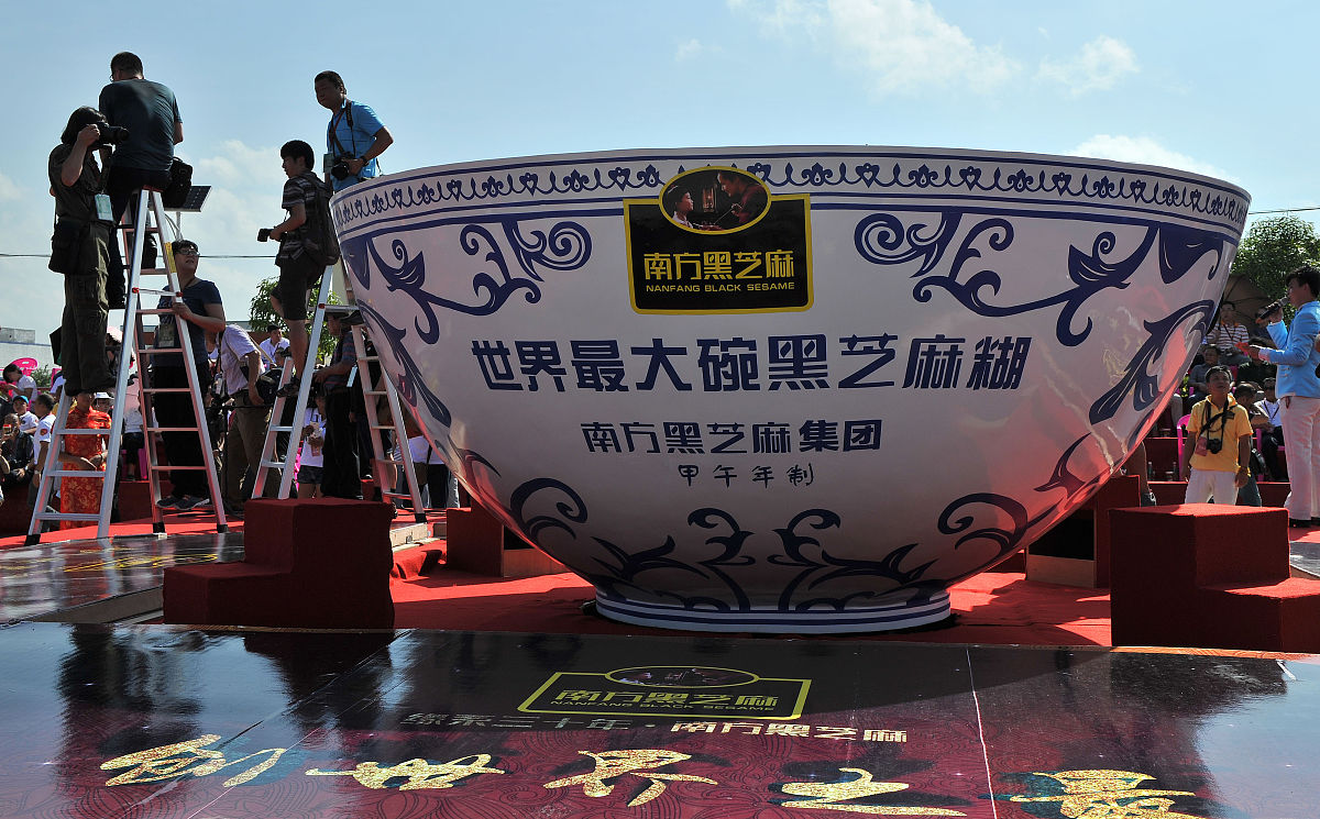 2014年8月27日,广西容县街头,898名当地人同磨黑芝麻糊.随后直径3.49