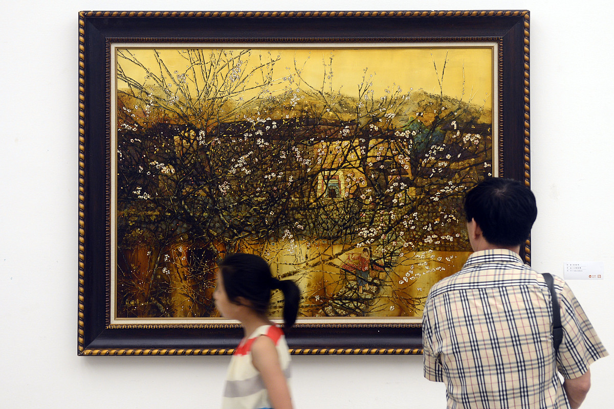 观众正在欣赏福建籍画家苏国伟的漆画作品《土楼映霞》.