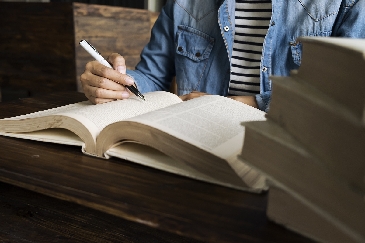 woman reading book in library.