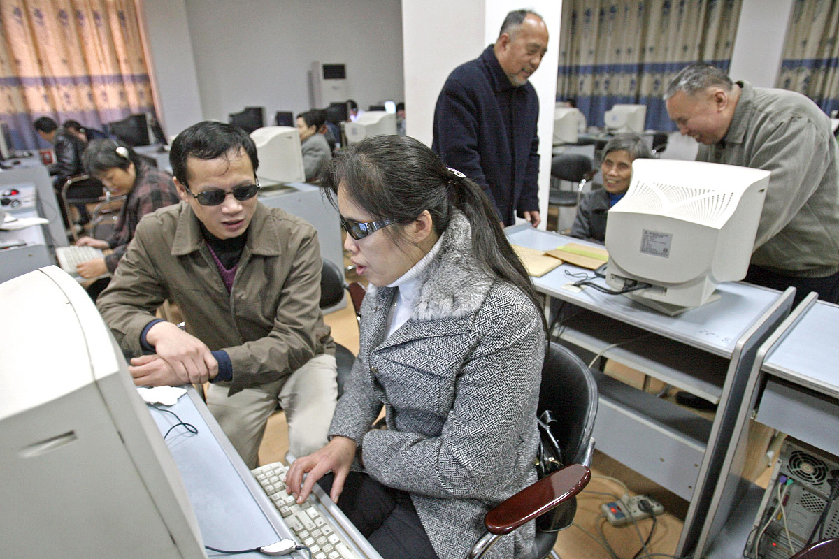 2006年11月25日,武汉,盲人电脑培训班.  电脑培训老师胡迅(左)利用课