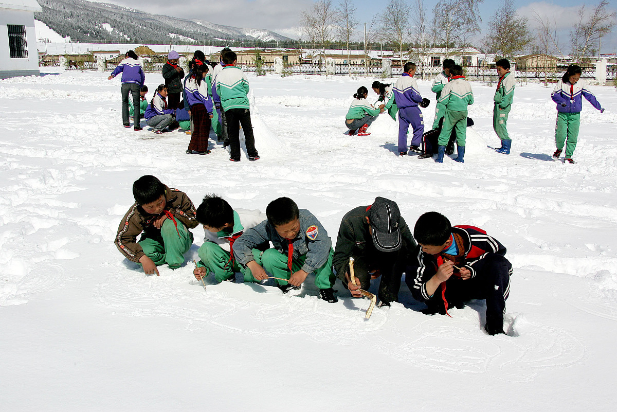 2007年5月24日,新疆哈密市白石头乡学校的学生(前排)在雪地上绘画.+++