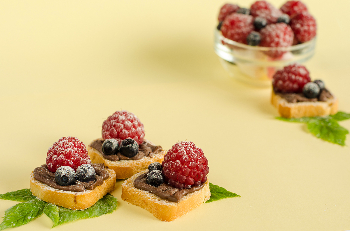 decorated sweet desserts with nutella cream,raspberries and blue