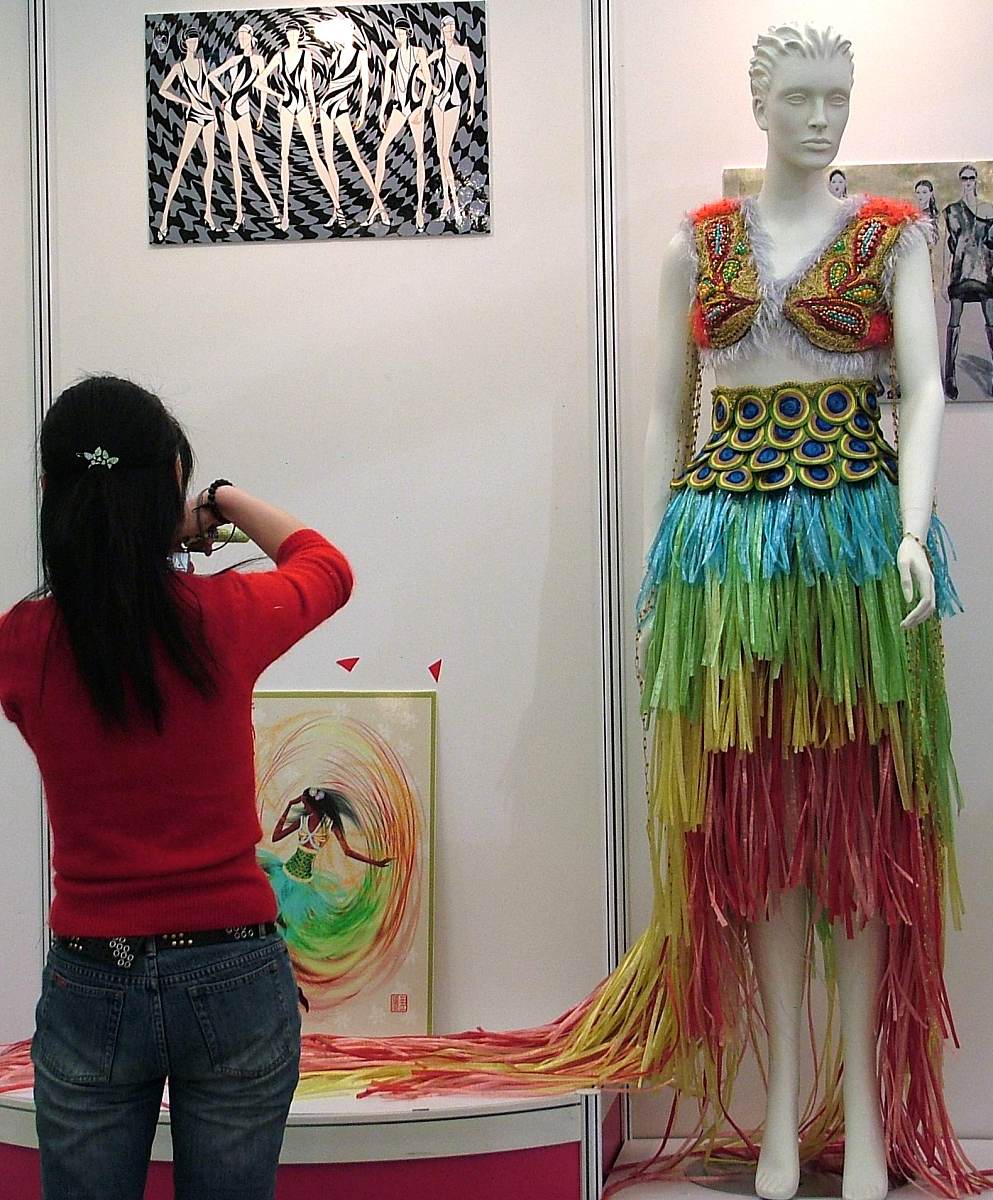 我有一个服装设计作品论文主题是《线》表达在亲密关系中的关心带来的温暖与束缚在作品中将许多丝带与毛线编织在一起可以写一段设计风格的描述吗