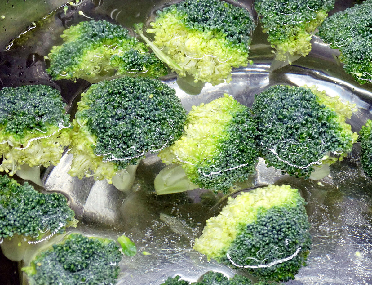 图为胡萝卜炒西蓝花的制作过程 西蓝花洗净用剪刀剪成小朵,放入淡盐水