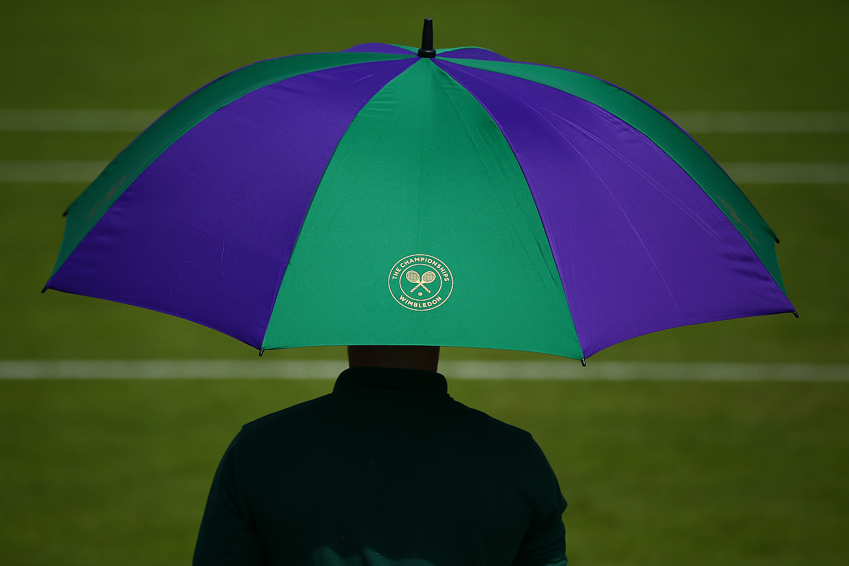 london, england - june 28:  an umpire sits undernieth an umbrell