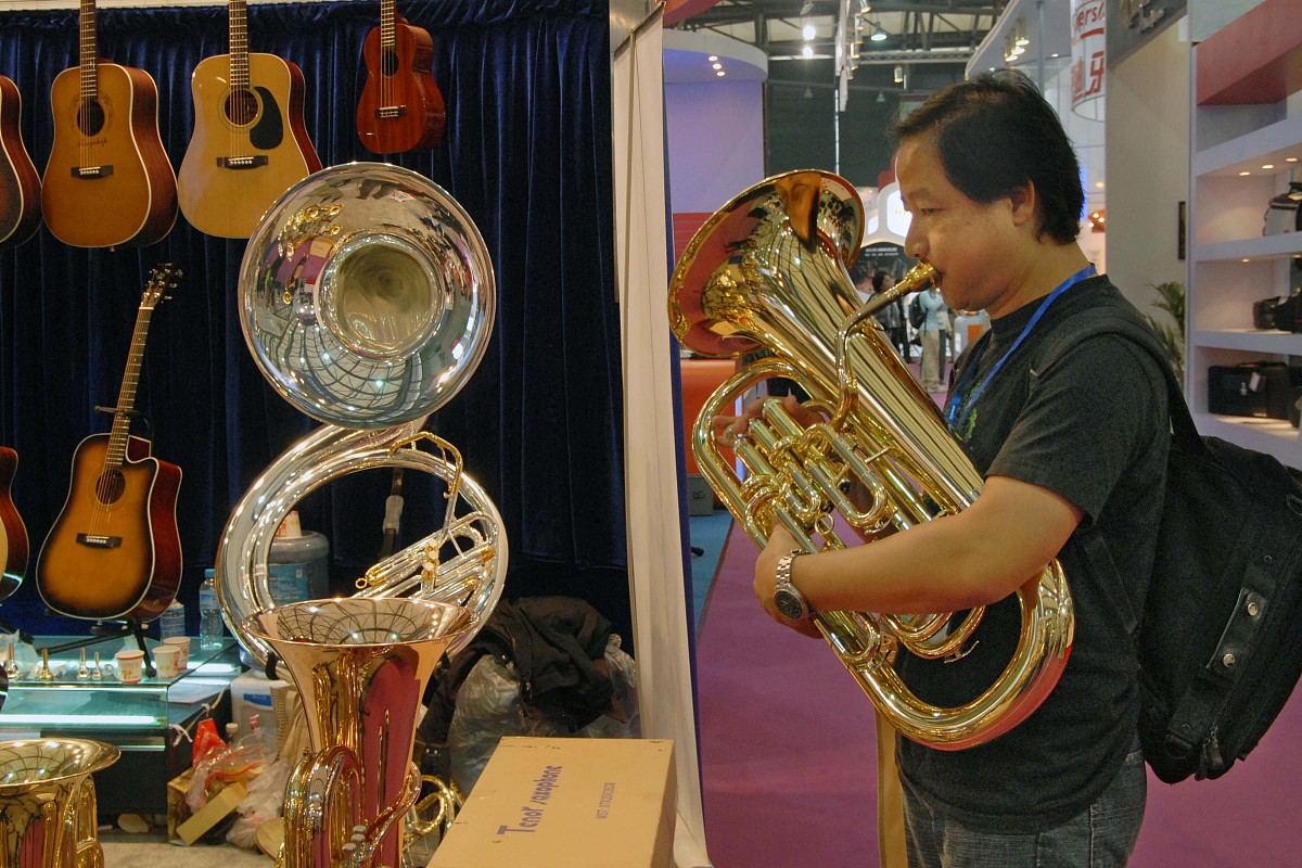 ***_***2009年10月13日,一音乐爱好者在展会现场吹奏铜管乐器.+++_+++