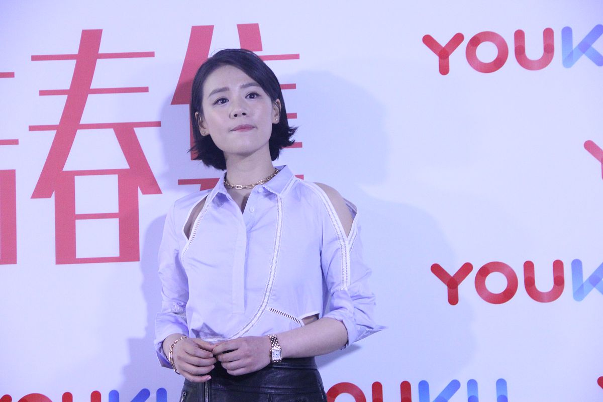 马思纯身穿浅蓝色镂空衬衫,下穿黑色拉链绑带高腰皮裙,脚踩粉色麂皮亮