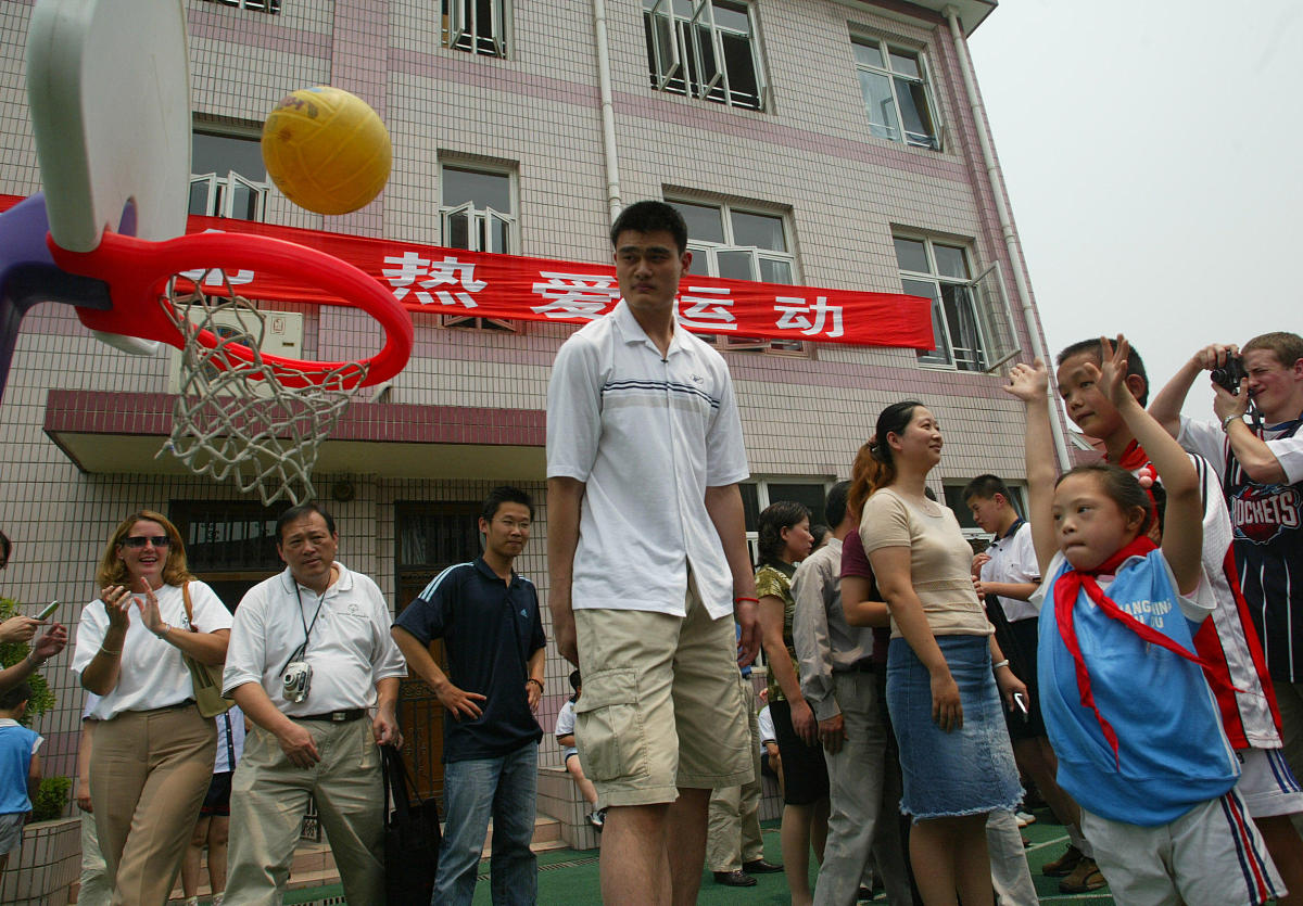 2004年6月11日,姚明来到长宁区辅读学校参观.教小朋友投篮+++_+++姚明