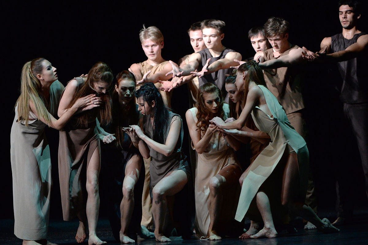 场景描述：一个穿短裤的裸体主义亚洲女人在大街上跳舞