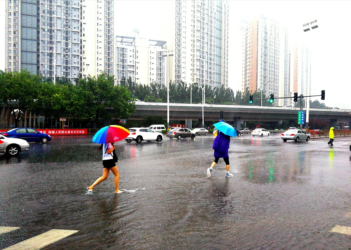 【独家】北京迎来强降雨天气 民众冒雨出行