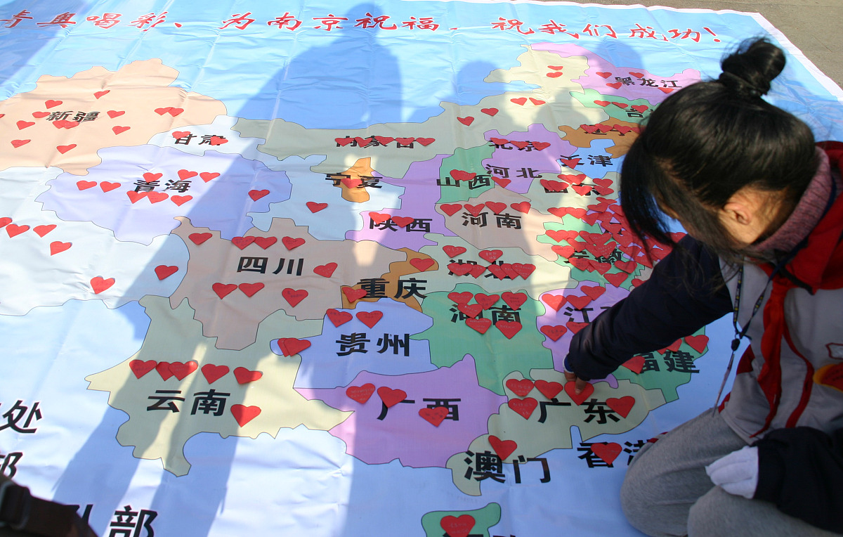 ***_***2009年12月31日, 江苏南京,一位中学生在粘贴广东游客签名的心
